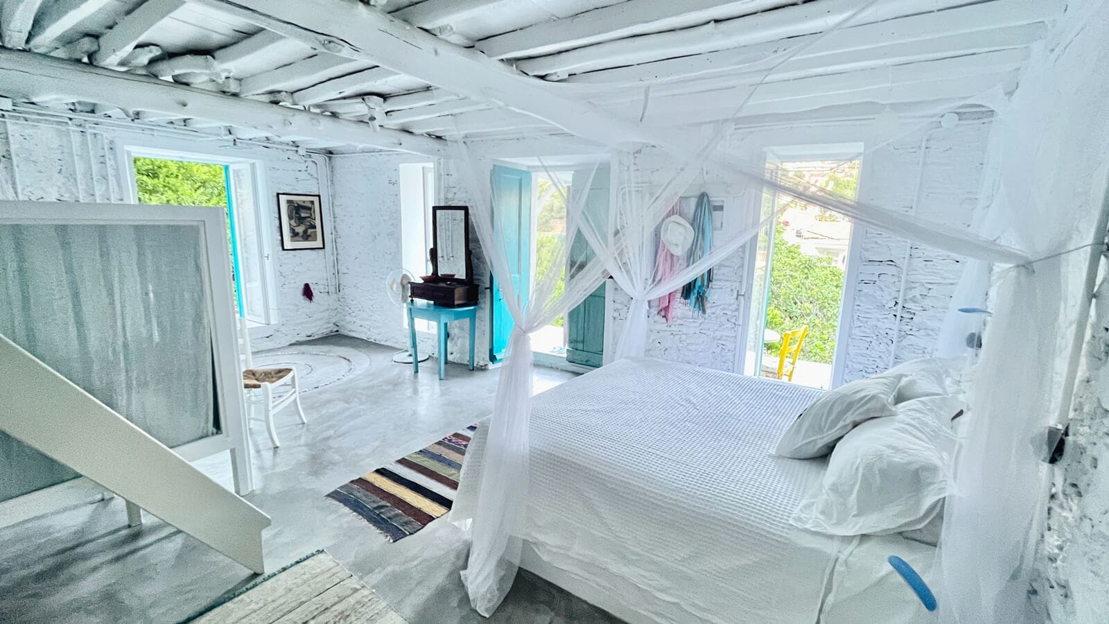 Plomari, Lesvos luxury villa rental: bright main room with romantic four-poster bed, modern amenities and balcony for the ultimate Greek island getaway.